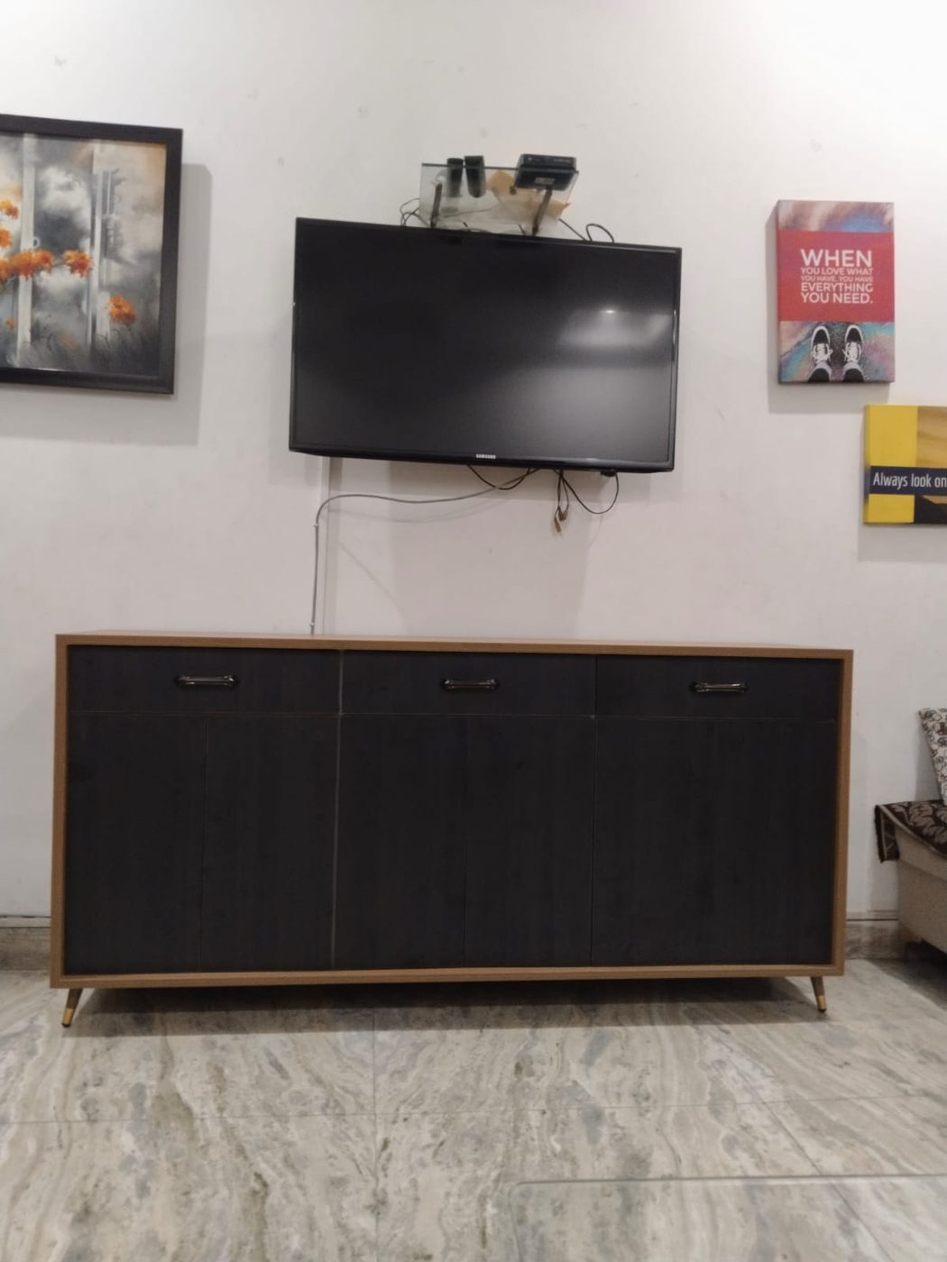 Sideboard console beneath a wall-mounted TV, walnut frame and black doors